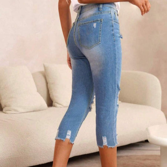 Pantalones vaqueros de mujer con aspecto usado, rotos y bajo sin rematar.