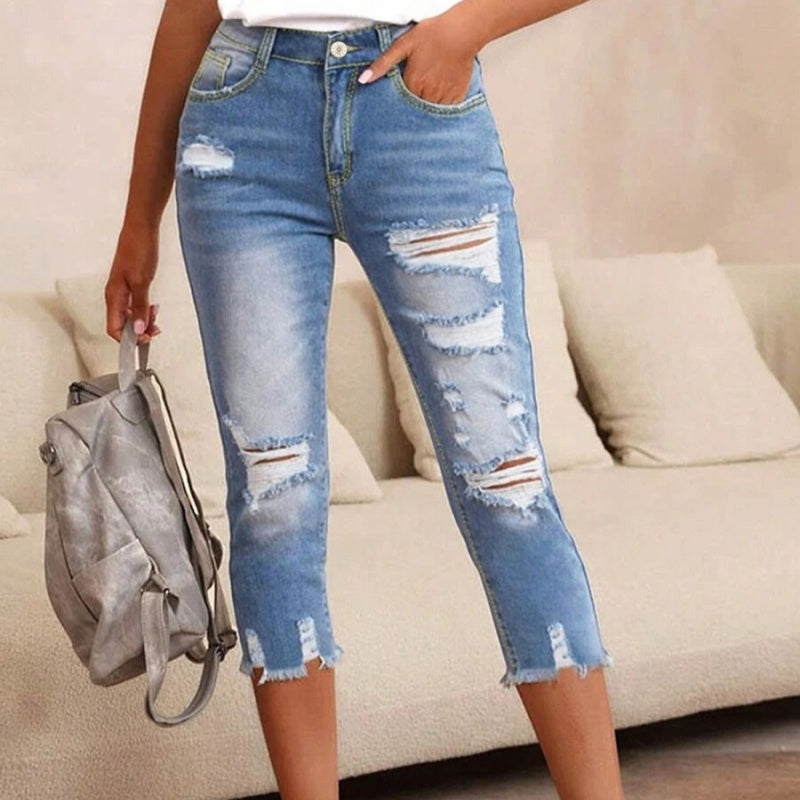 Pantalones vaqueros de mujer con aspecto usado, rotos y bajo sin rematar.