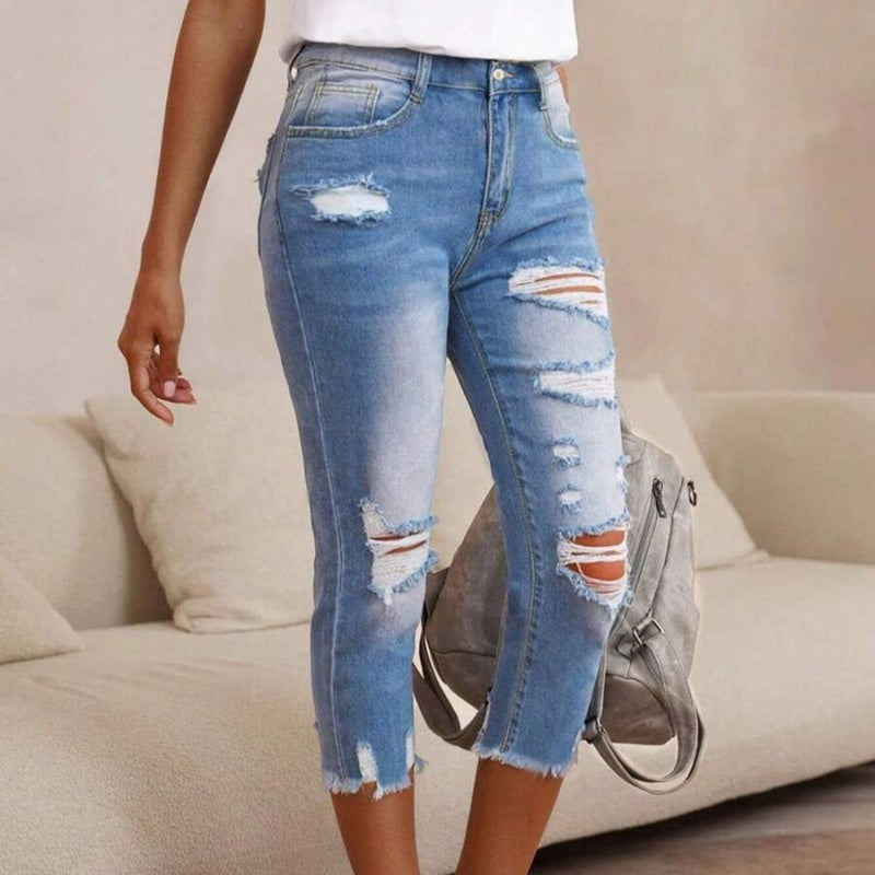 Pantalones vaqueros de mujer con aspecto usado, rotos y bajo sin rematar.