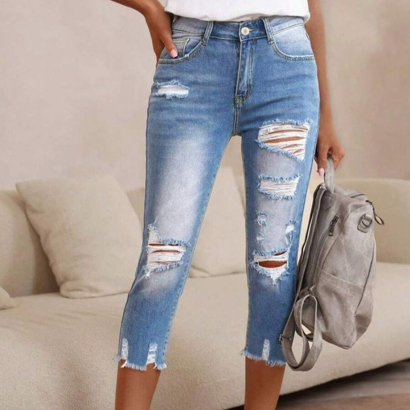 Pantalones vaqueros de mujer con aspecto usado, rotos y bajo sin rematar.